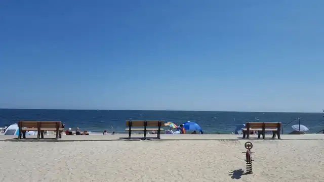 Sandy Cape Cod beach with benches facing the water